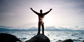Man with outstretched hands by ocean, subconscious mind power techniques