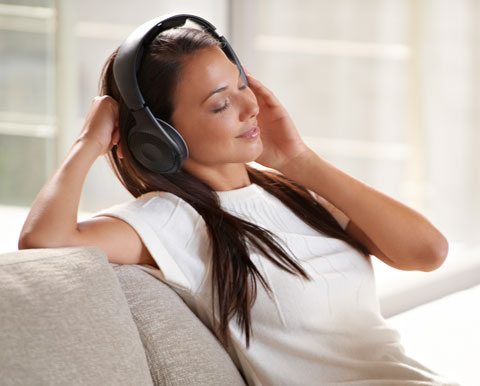 Relaxation Music, Attractive Woman Sitting On Couch Listening To Music On Headphones.