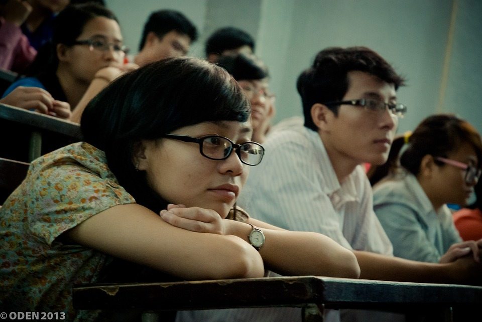 subliminal messages girl-at-desk leaning on folded arms ina college class