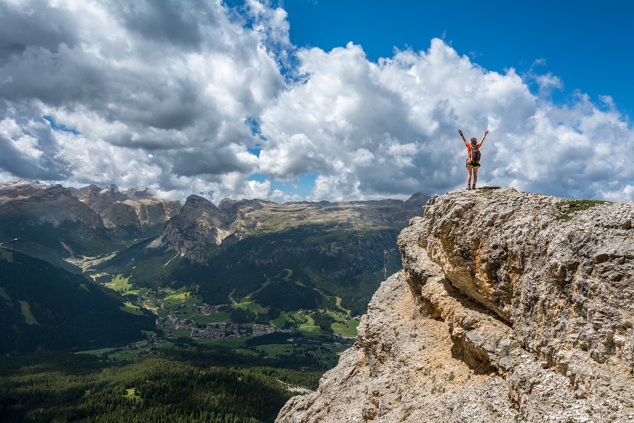 Visualization Techniques person with arms outstretched overhead on cliff over looking a beautiful vista