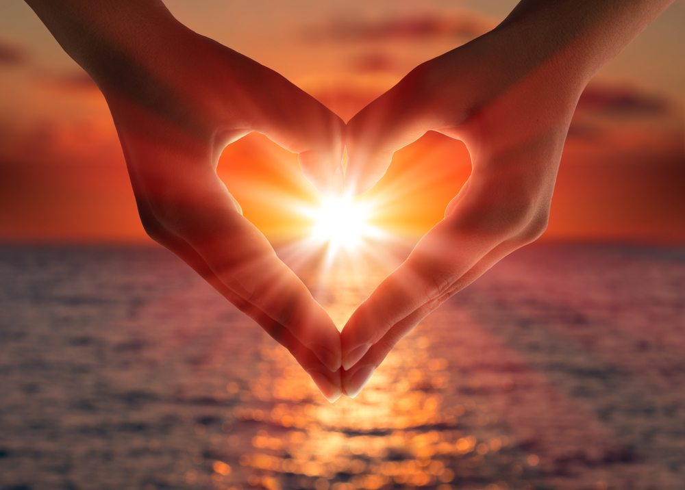 Positive affirmations two hands making a hear shape with sunset center of the heart