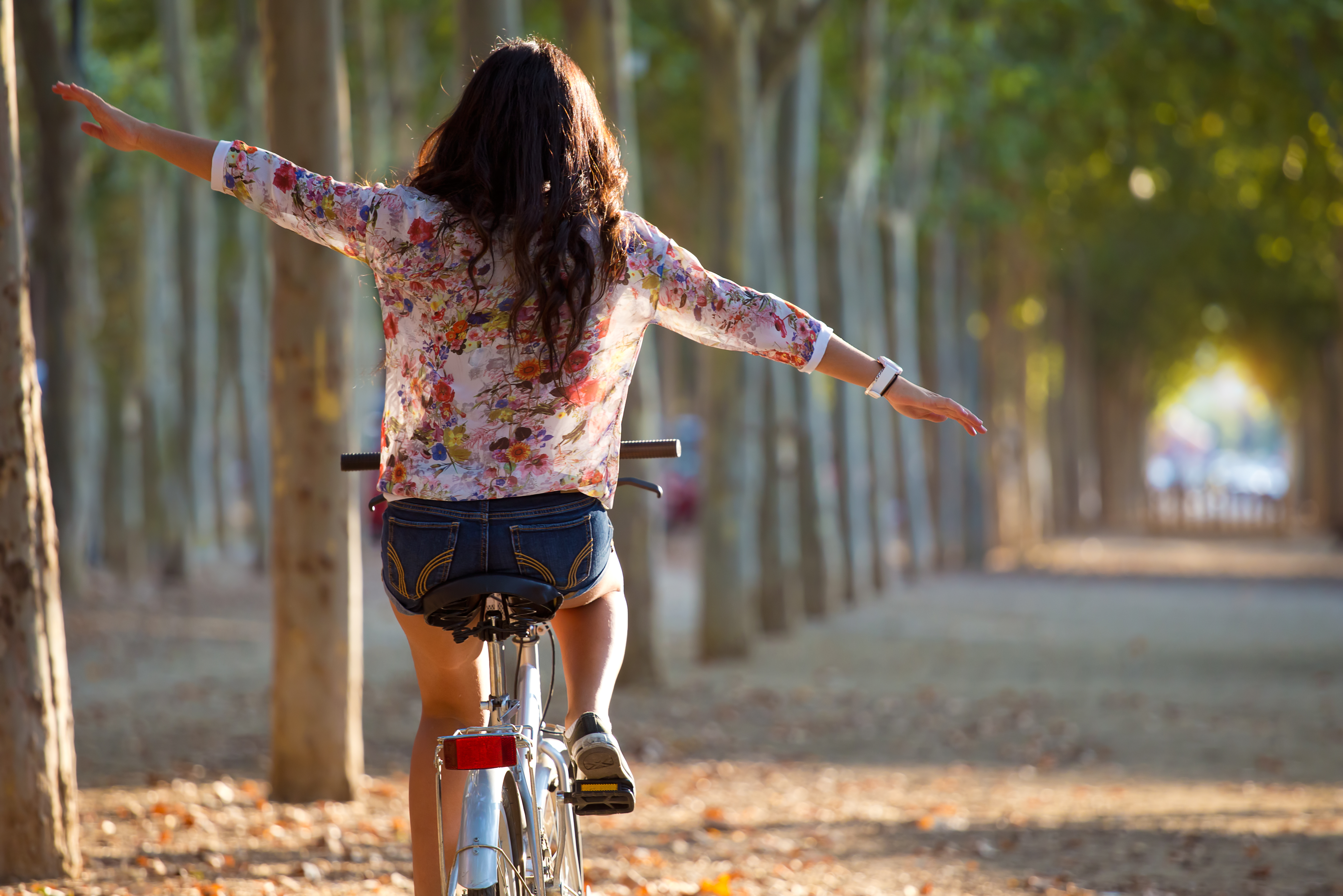 Self Hypnosis Audio - Back of a girl riding a bike with arm outstretched