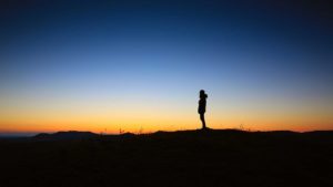 spiritual awareness hiker standing in sunset