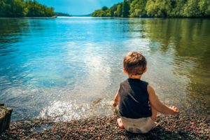 how to get rid of limiting beliefs - child playing by lake 