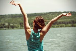 feeling stuck in life - happy woman, enjoying the moment on beach