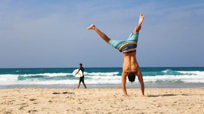 Natural Ways To Increase Energy Levels - Man Doing Handstand On Beach