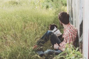 how to attract wealth - man relaxing with dog